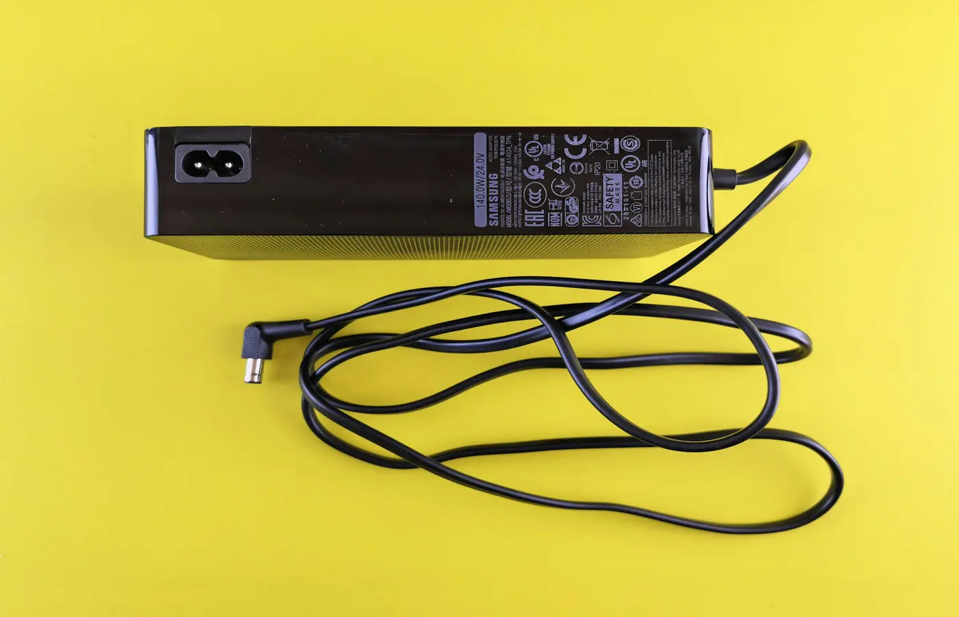 Black power adapter with cord on yellow background